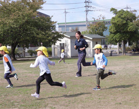 園児と保育士が園庭で遊んでいる